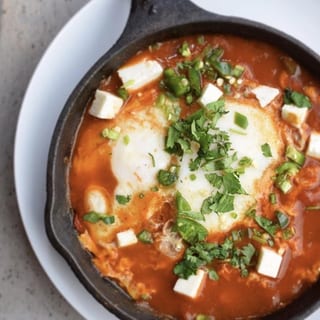 Shakshuka, 2 Eggs Poached in Tomato Sauce, Shredded PB cheese, Onions, Cilantro, Serrano Peppers (V)s 1/2 pita